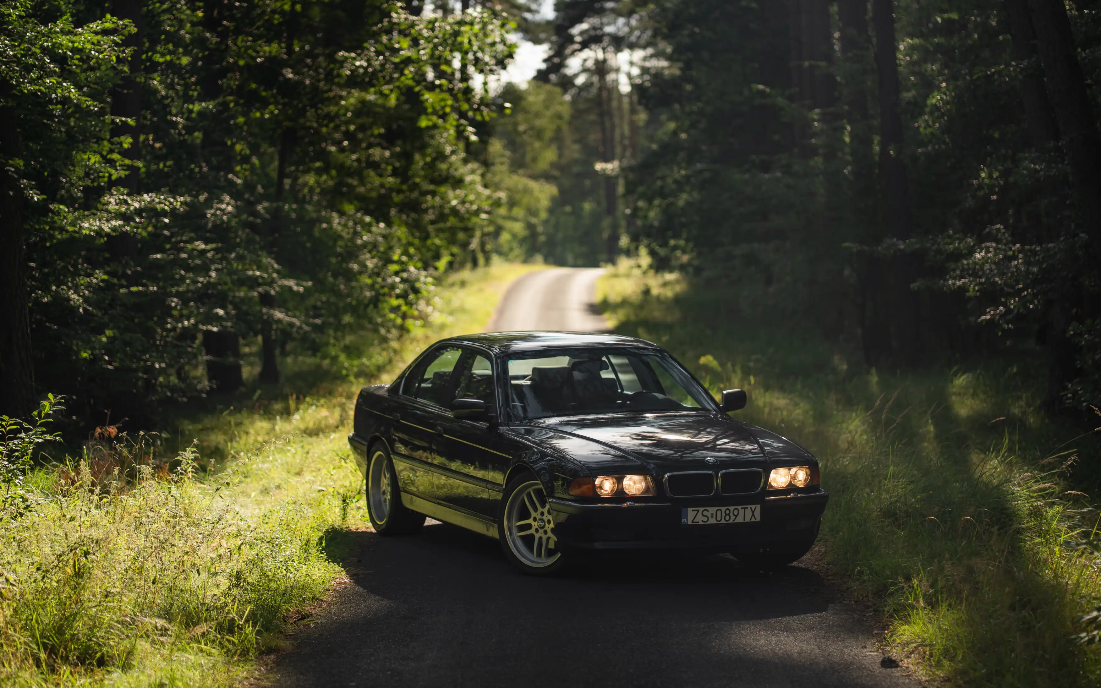 Czarne BMW 740i E38 z naszej kolekcji na leśnej drodze